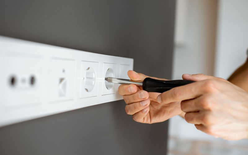 Electricien qui branche une prise electrique